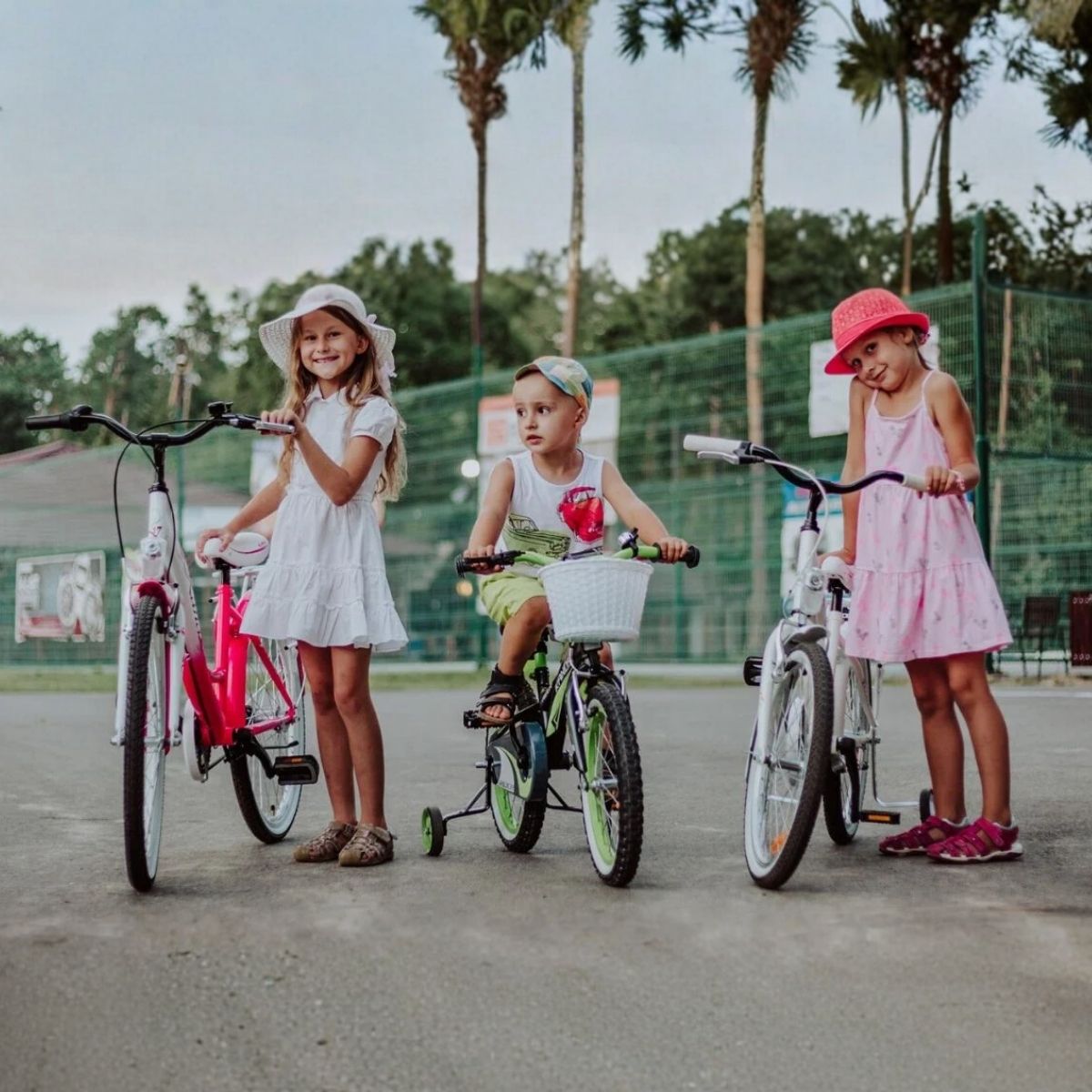 Tre børn cykler i parken med cykler.